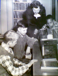 A photo of Dorcas Cavett working with three students